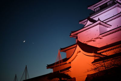 Low angle view of illuminated building against sky at night