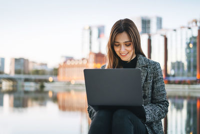 Portrait of young woman using laptop while sitting at home