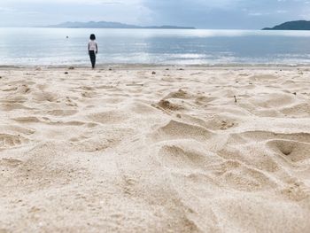 Man standing on beach against sky