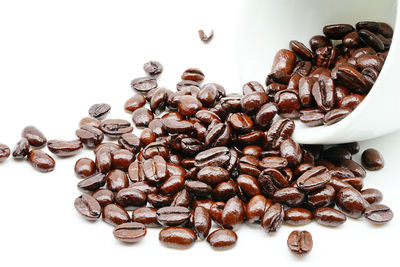 High angle view of coffee beans against white background