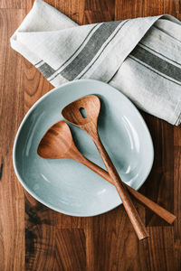 High angle view of empty plate with spoons on table