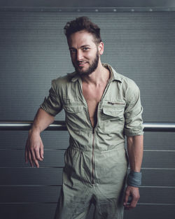 Portrait of young man standing against wall