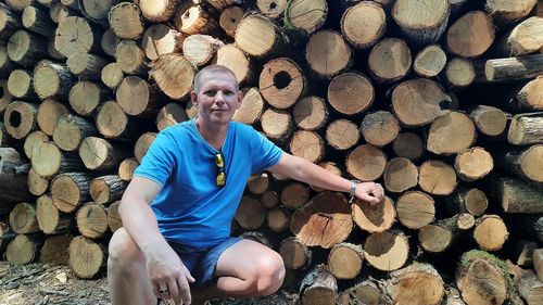 Full length of a young man sitting on logs