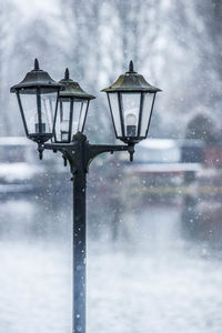 Low angle view of street light against sky during winter