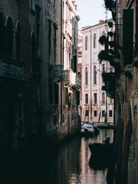 Canal amidst buildings in city at night