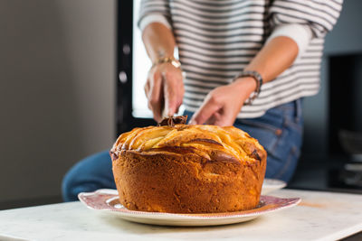 Young beautiful woman cutting homemade apple pie at the modern kitchen