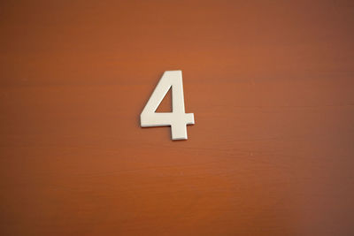 Low angle view of number 4 on brown door