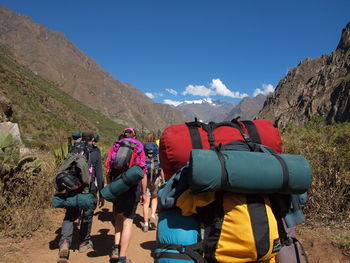 Rear view of hikers walking amidst mountains