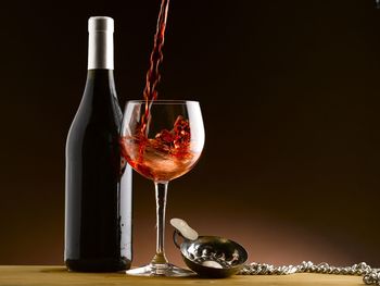 Wineglass on table against black background