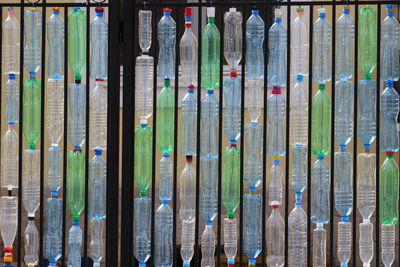 Full frame shot of plastic bottles arranged amidst railing