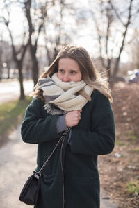 Portrait of woman standing in park during winter