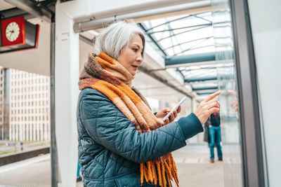 Side view of woman standing against wall