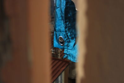 Close-up of blue fabric seen through wall