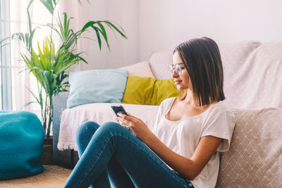 Woman using smart phone at home