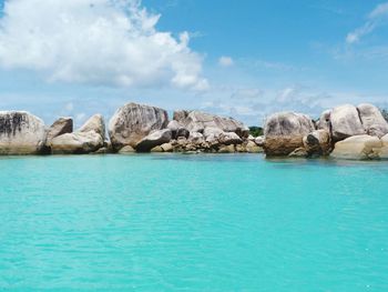 Scenic view of rocks in sea against sky