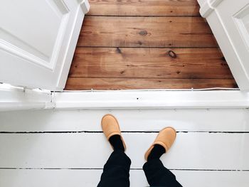 Low section of person in slipper standing in front of open door