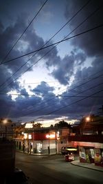 Cars on illuminated street against sky