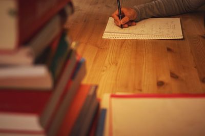 High angle view of person writing on book at table
