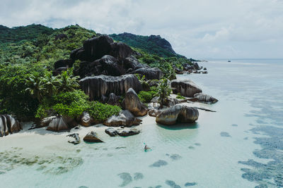 Scenic view of rocks on beach against sky