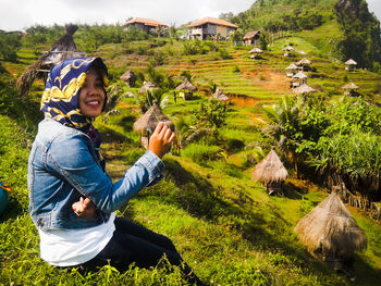 Young smiling woman sitting on grassy field