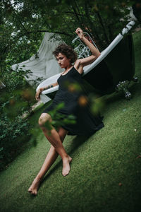 Young woman with arms raised in park