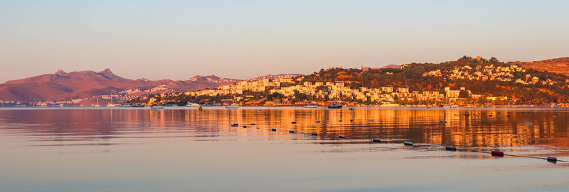 Scenic view of lake against clear sky during sunset