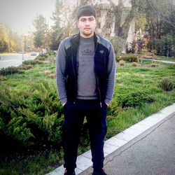 Portrait of young man standing against plants