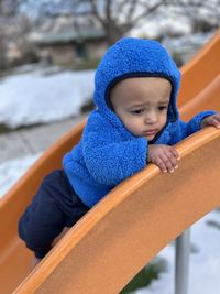 Side view of boy sitting on railing