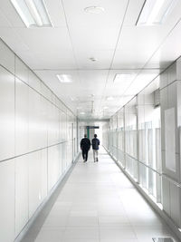 Rear view of men walking in corridor