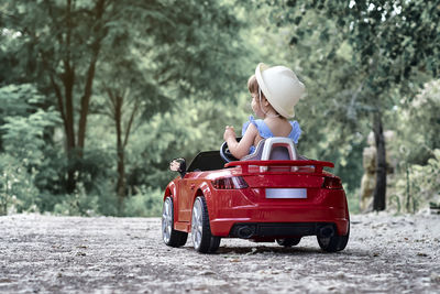 A girl riding a toy car