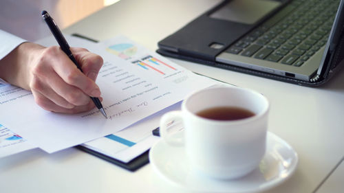 Midsection of businesswoman working on table