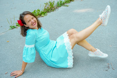 Portrait of smiling woman sitting on road