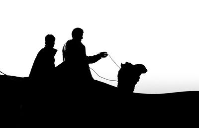 Low angle view of silhouette people against sky