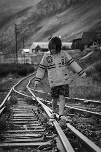 Rear view of boy on railway tracks