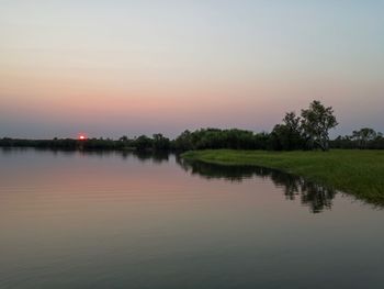 Scenic view of lake against sky at sunset