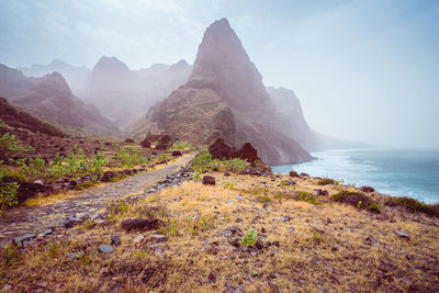 Scenic view of sea and mountains against sky