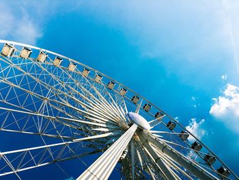 Low angle view of ferris wheel against blue sky