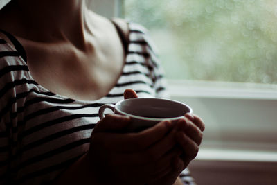 Close-up of hand holding coffee cup