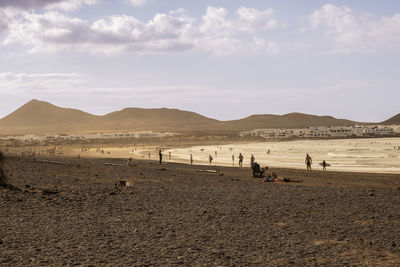 People at beach against sky