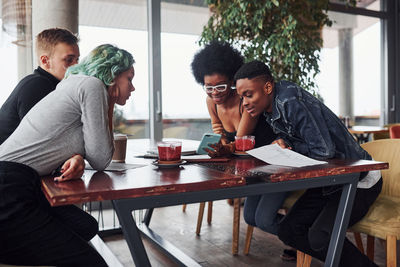 Group of multi ethnic people with alternative girl with green hair is working together