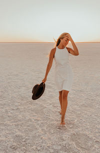 Full length of woman standing at beach