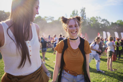 Portrait of smiling young woman with friend at music festival