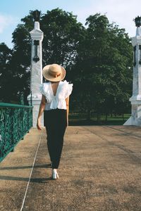 Rear view full length of woman on walkway at park