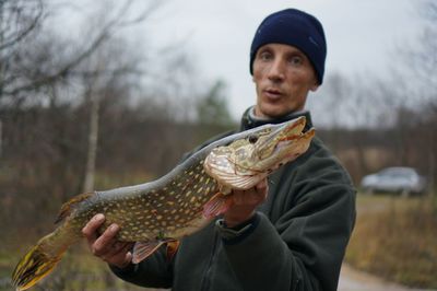 Midsection of man holding fish