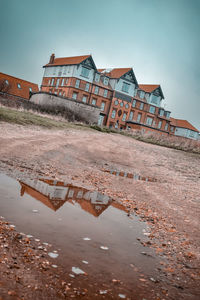 Abandoned building by river against sky