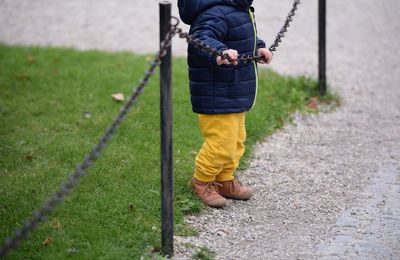 Low section of boy walking on swing