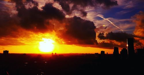 Silhouette cityscape against sky during sunset