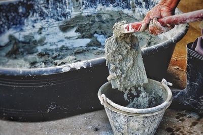 Midsection of man mixing cement 