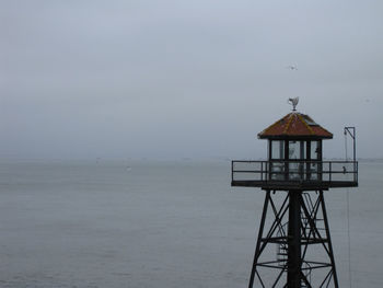 Lifeguard hut in sea against sky