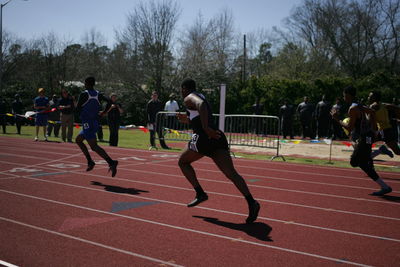 Runners running on track at playing field